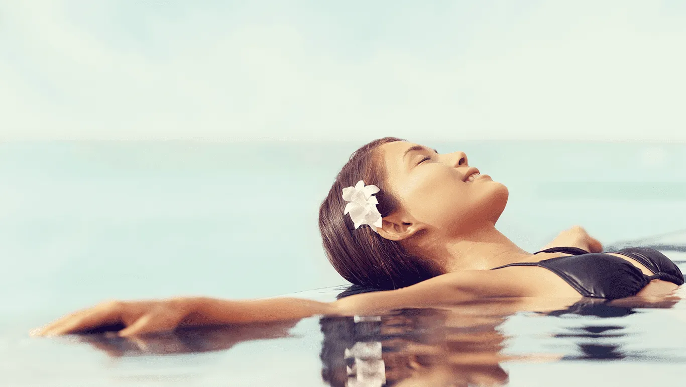 Woman with a flower in her hair relaxing in calm sea water